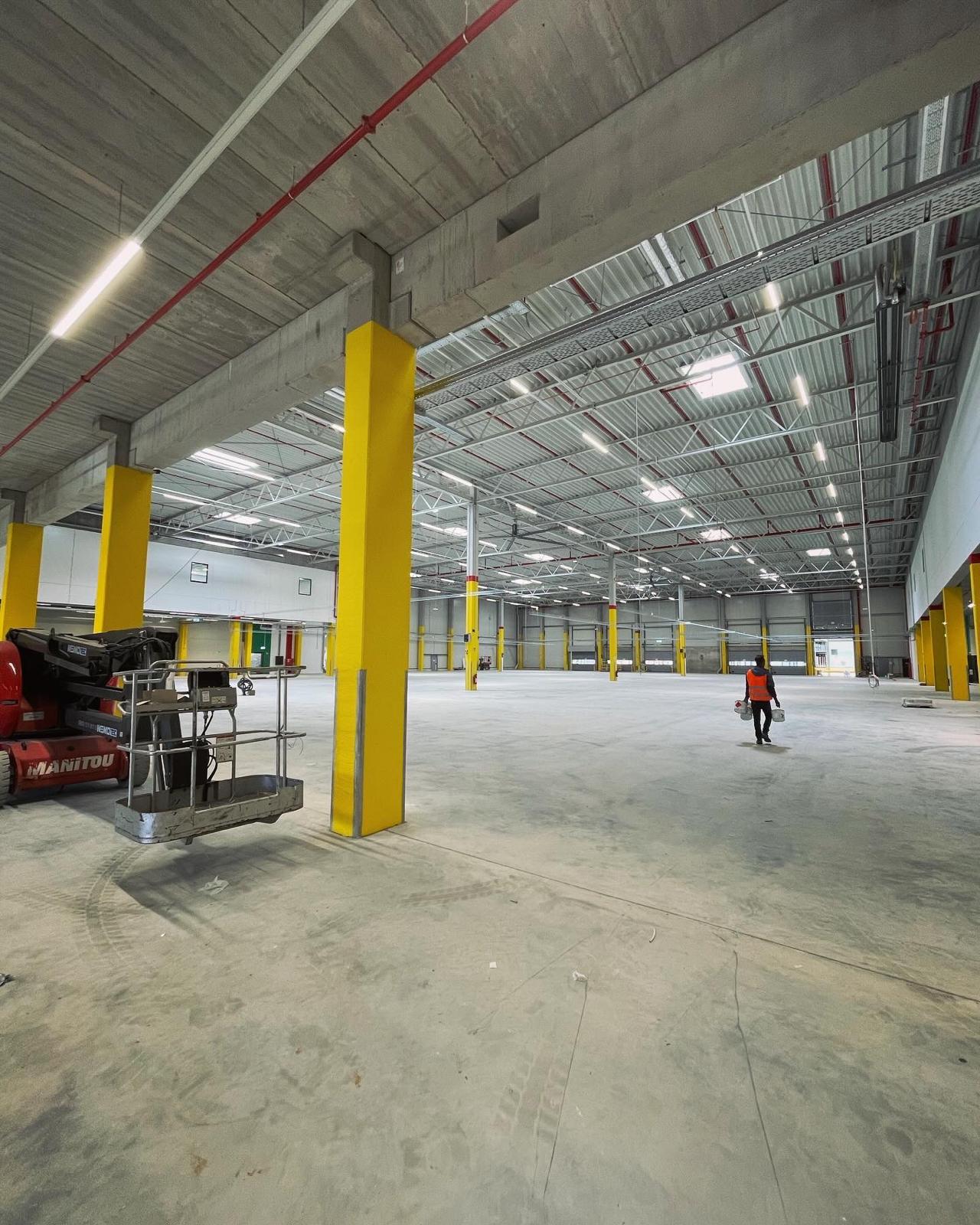 Průmyslová hala s elektroinstalacemi a žlutými sloupy